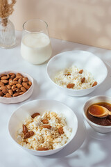 cottage cheese in a white bowl with nuts and honey on a light ba