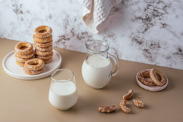 milk in a glass and bagels on a light background
