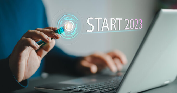 2023 start. Finger about to press a button with the text 2023 start. Happy new year. New Year two thousand and twenty three is coming concept.