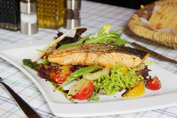 Baked salmon with vegetables and salad.