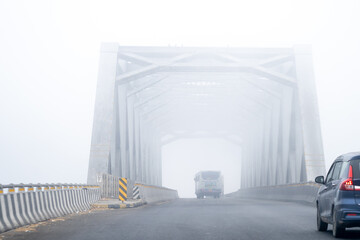 Large iron bridge mostly empty during a cold winter morning with dense fog in delhi, haryana,...