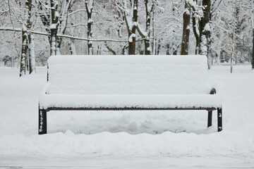 Bench in the park in the snow in winter.