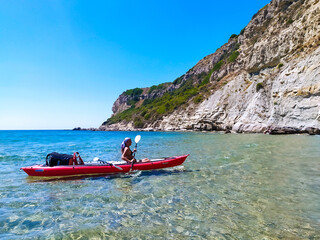 Fototapeta na wymiar Isola di Corfù, ragazza in viggio su kayak da mare