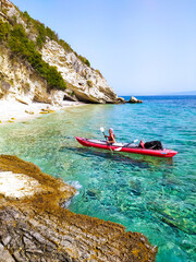 Isola di Paxos, ragazza in kayak tra le scogliere e le grotte marine