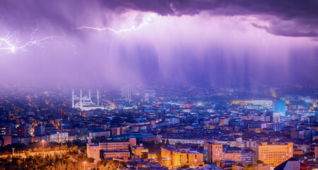 Lightning thunderstorm flash over the city at night sky - Lightning storm over city with rain -...
