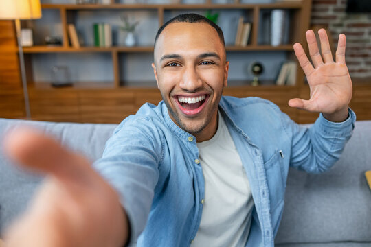 Photo of handsome guy in living room enjoy weekend making selfies speaking skype with friends showing new flat modern apartment indoors casual dressed