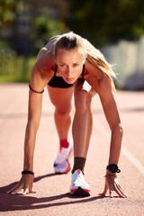 Obraz premium Woman getting ready to start on Stadium - summer outdoors training.
