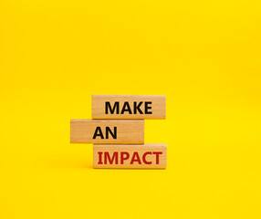 Make an impact symbol. Concept word Make an impact on wooden blocks. Beautiful yellow background. Business and Make an impact concept. Copy space