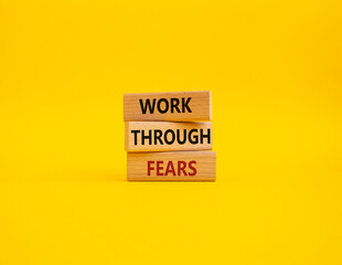 Naklejka premium Work through fears symbol. Wooden blocks with words Work through fears. Beautiful yellow background. Business and Work through fears concept. Copy space.