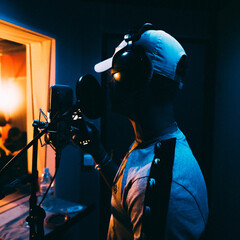 homme dans un studio d'enregistrement avec casque son et microphone rap - obrazy, fototapety, plakaty