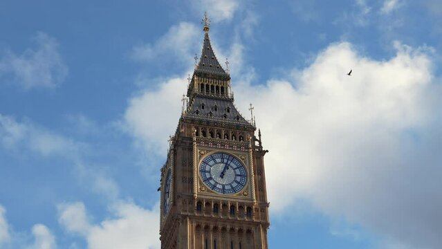 4K video with the landmark clock from Big Ben tower in London during a sunny day with blue sky and white clouds. Travel to England.