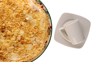 One homemade cream cake on ceramic dish with coffee cup and saucer, close-up, top view.