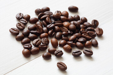 Pile coffee beans on white  wooden texture background
