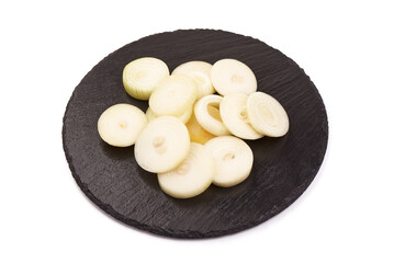 Onion slices on a slate plate, isolated on white background.