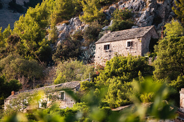 Fototapeta na wymiar Wonderful, old, stone house with small windows and stone rooftop on the steep, rocky slope of Vidova Gora mountain, located on Brac island, Croatia