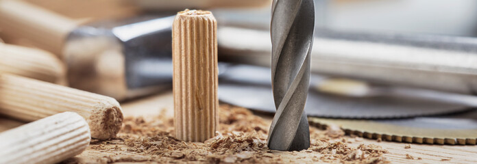 drill bit makes hole in wooden oak board for wooden dowel.