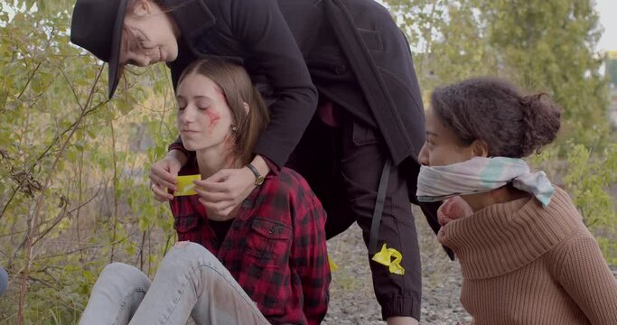 She seals the victim's mouth. Imitation of violence against a person, a hostage. Spot abrasion on the face. The second girl is gagged.