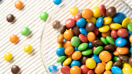 A vibrant display of small colorful candies in a glass bowl, ready to add a pop of color to your design.
