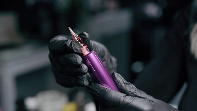 Cosmetologist preparing ink machine for microblading procedure in beauty salon. Close up.