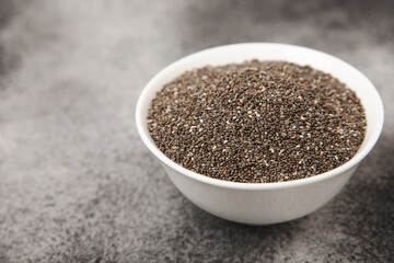 Chia seeds in a bowl on a black texture background.Superfood and axiontidant. Diet. Close-up. Place for text. Copy space.