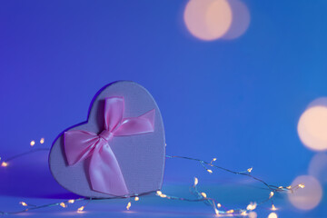 Gift box in the shape of a heart and a garland, the concept of Valentine's day, romance and love, copy space.