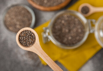 Chia seeds in a spoon and bowl on a black texture background.Superfood and axiontidant. Diet. Close-up. Place for text. Copy space.