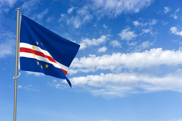 Fototapeta premium Republic of Cabo Verde Flag Over Blue Sky Background. 3D Illustration