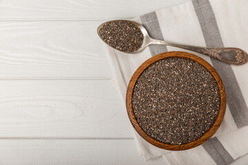 Chia seeds in a spoon and bowl on a white texture table.Superfood and axiontidant. Diet. Close-up. Place for text. Copy space.