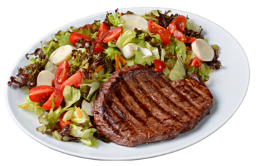 Grilled steak with green salad with hearts of palm and cherry tomatoes on white plate isolated on transparent background.