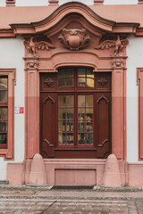 Elegant old doors adorned with intricate details in a decorated façade of a historical significant building, well-maintained, showing the craftsmanship of the ornate carvings and moldings.