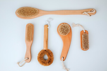 Set of brushes with wooden handles on a white background, eco friendly products. Flat lay