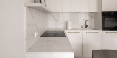 Warm white kitchen interior design, electric hob with integrated extraction. Modern kitchen interior concept