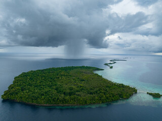 Storm clouds dump rain near a remote tropical island in the Solomon Islands. This beautiful country is home to spectacular marine biodiversity and many historic WWII sites.