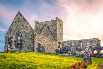 Ruins of the Burrishoole Abbey friary on top of the cemetery hill with numerous tombstones during...