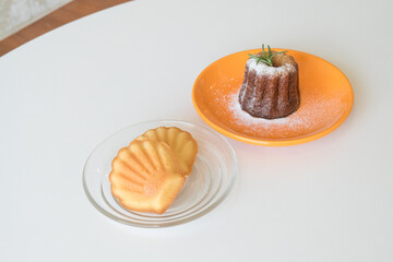 French traditional madeleine biscuits and Caneles de bordeaux on table,traditional French sweet dessert.