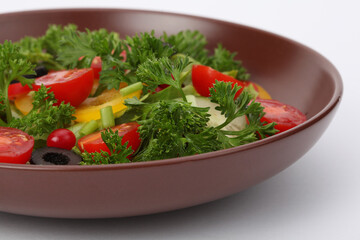 Tomato, cucumber, olives, parsley, pepper in salad close-up.