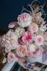 Beautiful flowers. Beautiful flower arrangement in a box on dark blue background on coffee table. Bouquet of tenders peonies a girl for mother's day, valentine's day, Woman's day 8 march.