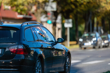 Cars moving on the road in city in autumn. View to the traffic with signs, trafficlights and cars