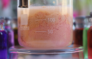Inorganic chemical reaction of the formation of a light brown insoluble compound of manganese sulfide in a beaker. - obrazy, fototapety, plakaty