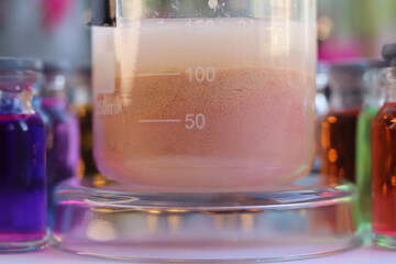 The formation of a brown-cream precipitate of manganese sulfide in a beaker. - obrazy, fototapety, plakaty