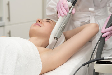 beautiful brunette will receive laser hair removal procedure on her arms and armpits. Body care....