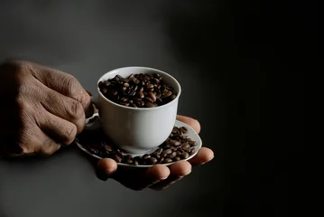 hand with cup of coffee beans roasted with the smell of fresh coffee stock photo