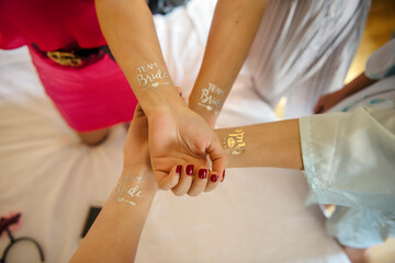 Bride and bridesmaids having fun with team bride tattoo