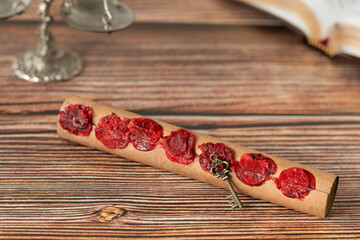 Scroll with seven seals, ancient key, antique weighing (balance) scales and bible book in the background on wooden table. Apocalypse, Christian prophecy and revelation, judgment day biblical concept.