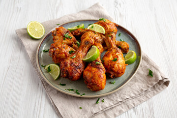 Homemade Grilled Jerk Chicken with Lime on a Plate, side view.