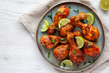 Homemade Grilled Jerk Chicken with Lime on a Plate, top view. Flat lay, overhead, from above. Copy space.