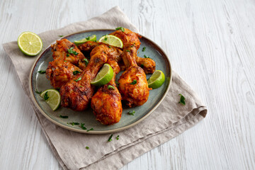 Homemade Grilled Jerk Chicken with Lime on a Plate, side view. Copy space.