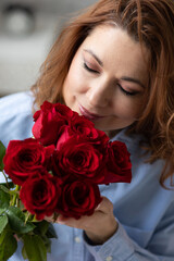 Portrait of a beautiful smiling young woman at home with a red gift box on Saint Valentine's day or Birthday. Happy day full of love. Emotions and happiness
