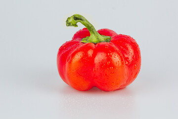 Red fresh bell pepper, paprika isolated with water drops on white background. Fresh ripe colorful bell pepper as a background, close up.