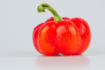 Red fresh bell pepper, paprika isolated with water drops on white background. Fresh ripe colorful bell pepper as a background, close up.